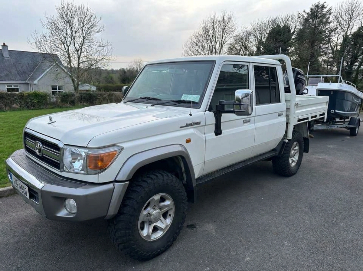 Front-left view of a white Land Cruiser pickup with tinted windows