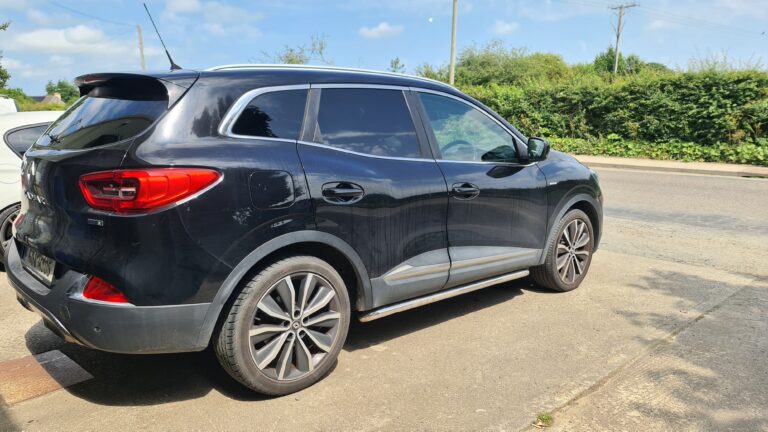 Rear three-quarter view of a black Renault Kadjar showing the tinted tailgate screen