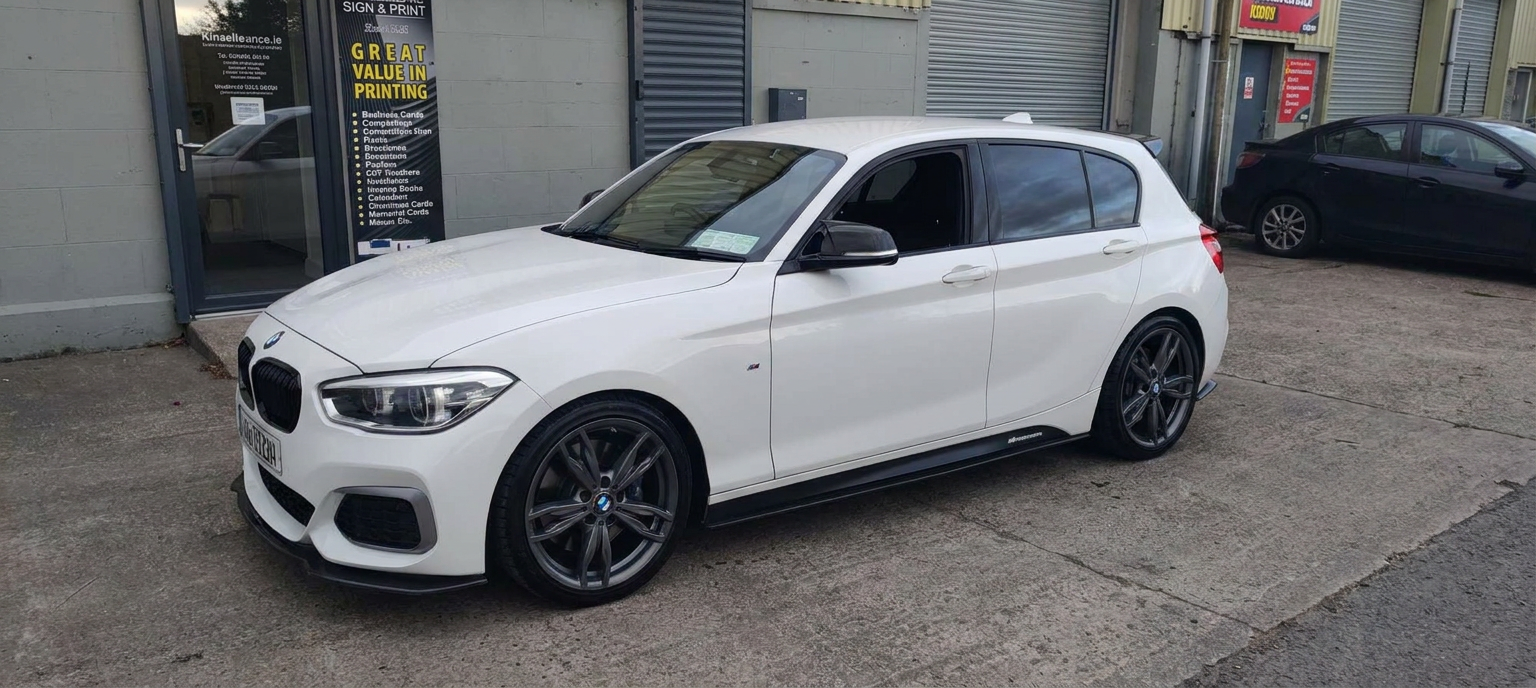 White BMW hatchback with tinted rear windows